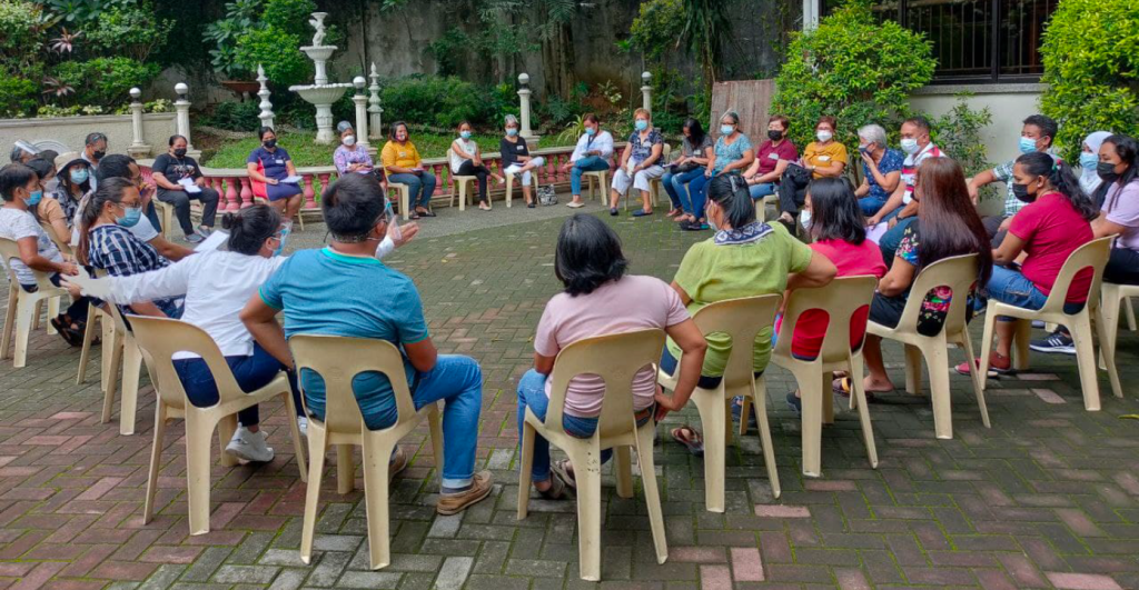 Group sitting in circle of chairs outdoors